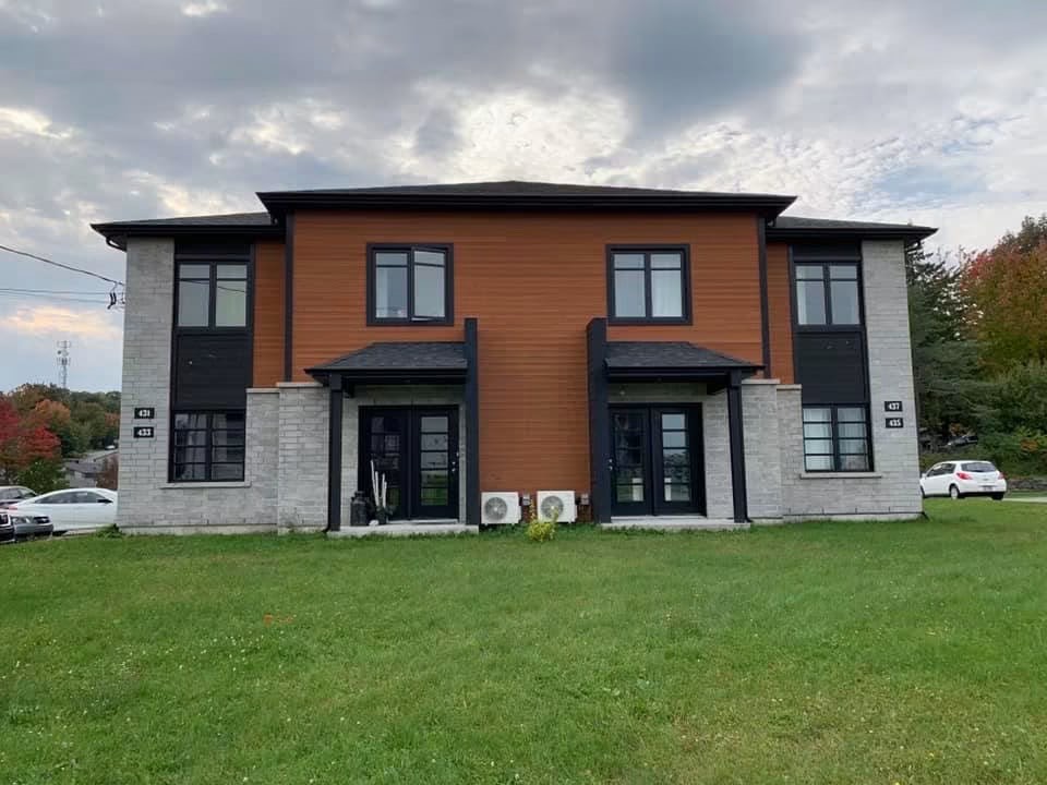 Immeuble de quatre logements avec revêtement de bois et brique en Estrie