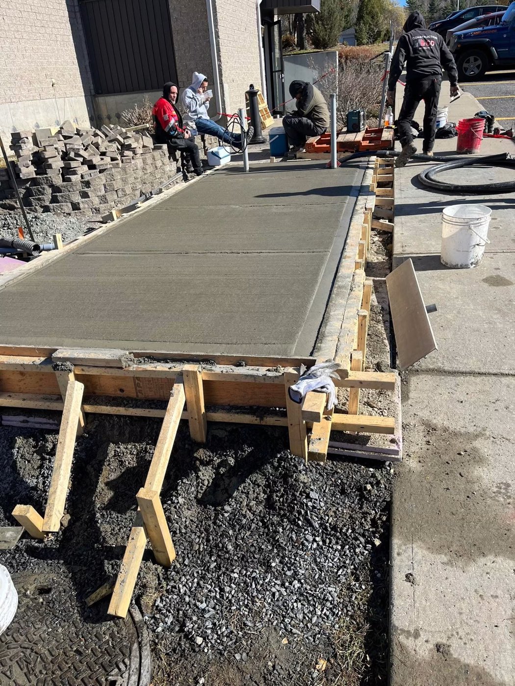 Coulée d'un trottoir de béton sur un chantier commercial par l'équipe de Construction C.D